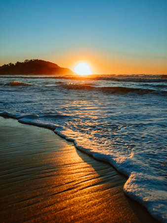 Sunrise on the beach and ocean waves.の写真素材