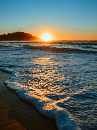 Sunrise on the beach and ocean waves.の写真素材