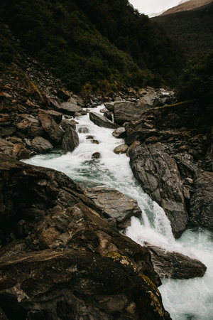 A stoney river runs through a valley in New Zealandの写真素材