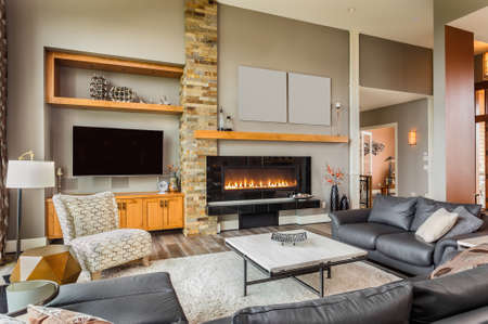 Furnished living Room in Luxury Home with Roaring Fireplaceの写真素材