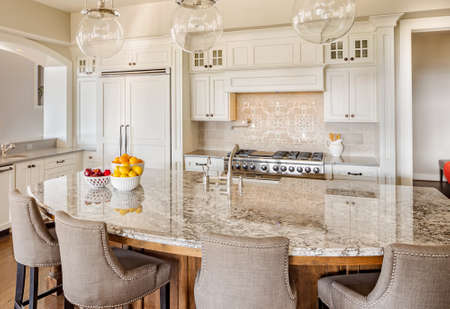 Kitchen with Island, Sink, Cabinets, and Hardwood Floors in New Luxury Homeの写真素材
