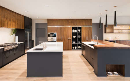 Kitchen Interior with Two Islands,  Two Sinks, Cabinets, and Hardwood Floors in New Luxury Homeの写真素材