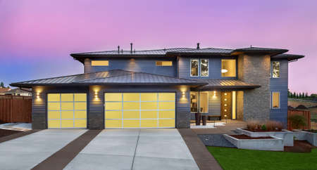 Beautiful Exterior of New Luxury Home at Sunset with Colorful Skyの写真素材