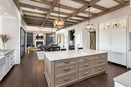 Beautiful open concept kitchen, dining room, and living room in new luxury home, with hardwood floors, fireplace, and dining table.の写真素材