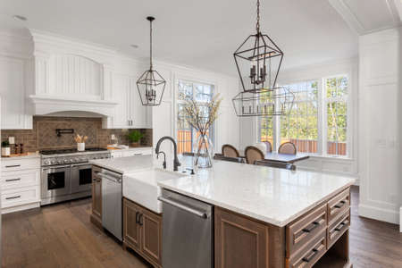 Beautiful kitchen in new traditional style luxury home, with quartz counters, hardwood floors, and stainless steel appliancesの写真素材