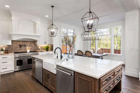 Beautiful kitchen in new traditional style luxury home, with quartz counters, hardwood floors, and stainless steel appliancesの写真素材