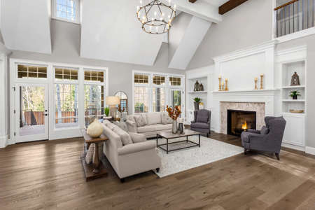 Beautiful living room in new traditional style luxury home. Features vaulted ceilings, fireplace with roaring fire, and elegant furnishings.の写真素材