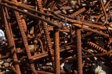 Rusty corroded stained metal pieces: wire, fitting, armature on a dirty concrete floorの写真素材