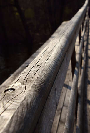 Wooden bridge handrail diagonal shot with dark water backgroundの写真素材