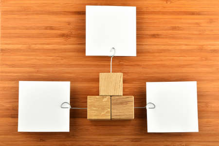Different Opinions - Three white paper notes with wooden holders in different directions on bamboo wooden background for presentationの写真素材
