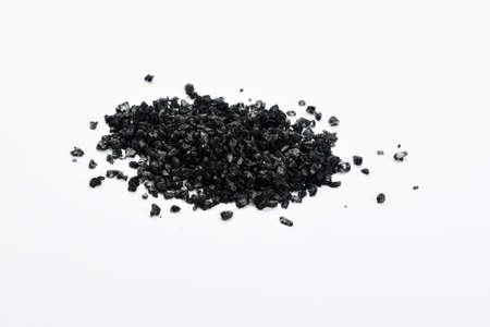 Handful of black Hawaiian sea salt isolated on white backgroundの写真素材