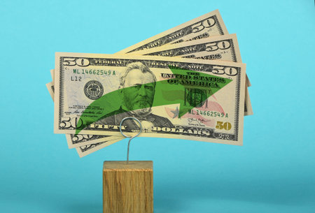 Growth and support of American economy and US dollar, tree fifty dollars banknote with green arrow up on two holders over blue backgroundの写真素材