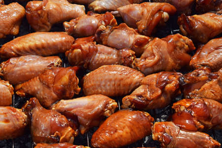 Chicken buffalo or teriyaki sauce raw wings cooked grilled on bbq smoke grillの写真素材