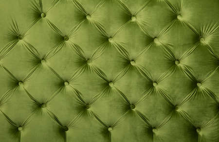 Green velvet capitone textile background, retro Chesterfield style checkered soft tufted fabric furniture diamond pattern decoration with buttons, close upの写真素材