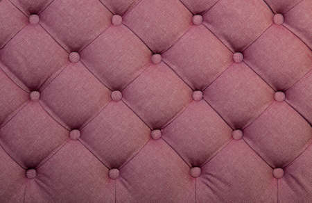 Pink capitone textile background, retro Chesterfield style checkered soft tufted fabric furniture decoration with buttons, close upの写真素材