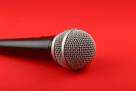 Black and silver vocal microphone side view close up on red backgroundの写真素材