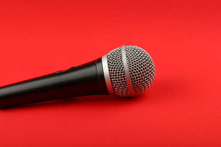 Black and silver vocal microphone side view close up on red backgroundの写真素材