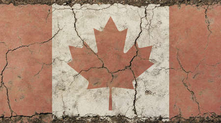 Old grunge vintage dirty faded shabby distressed Canadian Canada flag with red maple leaf over white background on broken concrete wall with cracksの写真素材