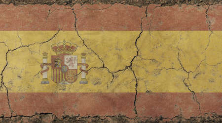 Old grunge vintage dirty faded shabby distressed Kingdom of Spain Spanish national flag background on broken concrete wall with cracksの写真素材