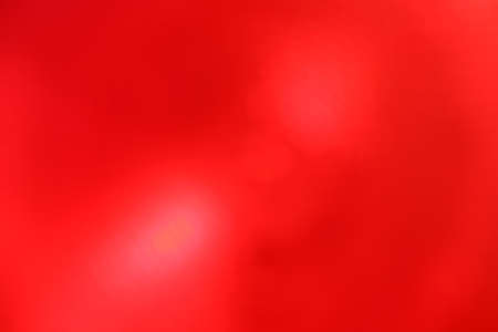 Red vivid abstract blur background with bright light lens flare spotの写真素材
