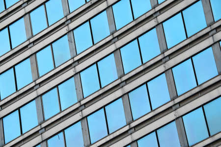 Blue glass windows of modern business office building, diagonal perspective, low angle view, close upの写真素材