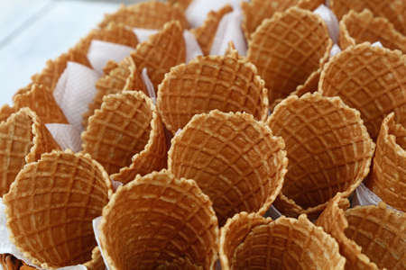 Several empty fresh wafer ice cream cone cornet cups with white paper napkins, close up, elevated high angle viewの写真素材