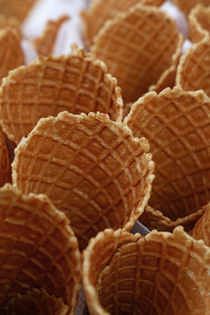 Several empty fresh wafer ice cream cone cornet cups with white paper napkins, close up, elevated high angle viewの写真素材
