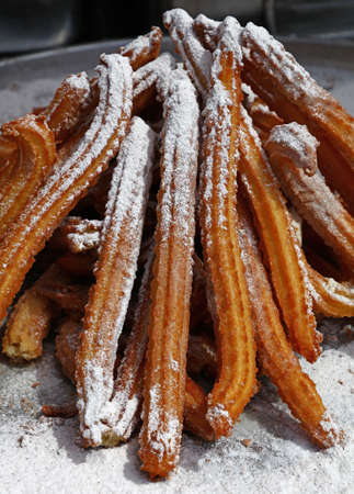 Heap of sweet fresh churros with sugar, traditional Spanish or Portuguese deep fried dough pastry snack cooked close up, high angle viewの写真素材