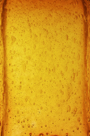 Background texture of solid transparent orange, yellow and brown color glass with pattern of air...
