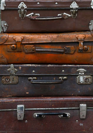 Stack of four old vintage antique grunge travel luggage brown leather suitcase trunks, close up, low angle front viewの写真素材