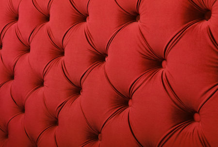 Scarlet ruby red capitone textile background with buttons, retro Chesterfield style soft tufted fabric furniture upholstery diamond pattern decoration, close upの写真素材