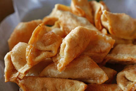 Close up portion of traditional Chinese Jiaozi deep fried dumplings on paper, high angle viewの写真素材