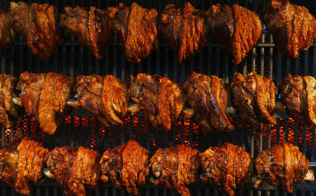 Several traditional Bavarian German roasted pork knuckles slowly cooked at rotating broiling rack...