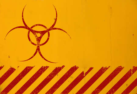 Dark red biohazard warning sign painted over grunge yellow background with copy spaceの写真素材
