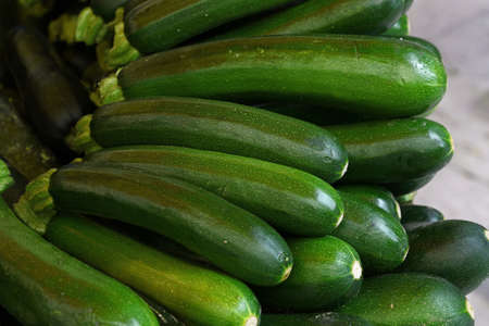 Close up fresh new green zucchini on retail display of farmers market, high angle viewの写真素材