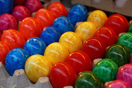 Close up many vivid colorful multicolor painted Easter chicken eggs in tray carton at retail display...