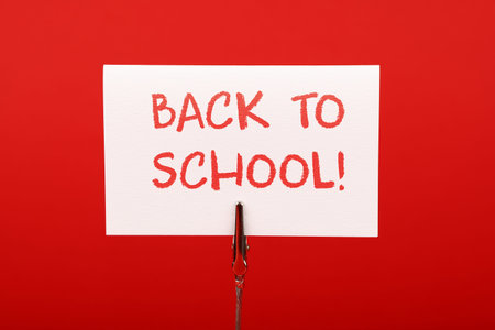 Back to school white crayon handwritten sign over red paper background