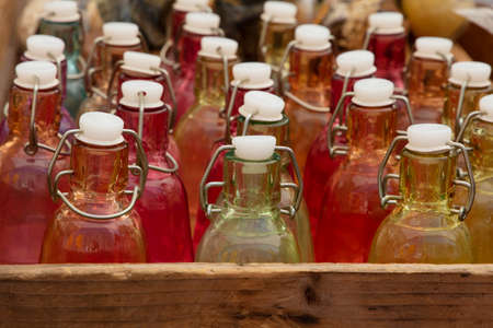Close up mixed color glass bottles with retro vintage sealing cap on retail displayの写真素材
