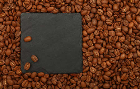 Close up one blank empty black slate board sign over brown roasted coffee beans backgroundの写真素材