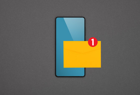 Close up one black smartphone with blank blue screen and yellow envelope of new message over grey...