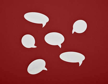 Group of six different shape blank empty white paper speech bubble callouts over red backgroundの写真素材