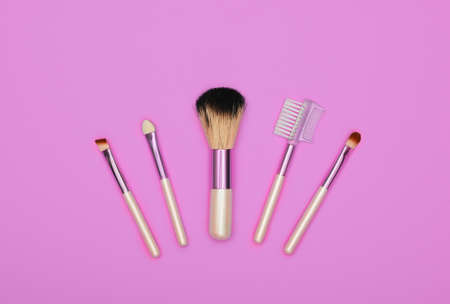 Close up set of different natural face makeup brushes over pink background, elevated top view, directly aboveの写真素材
