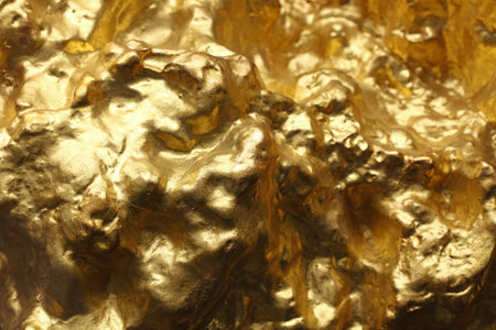 Close up big gold rock slug nugget uneven surface