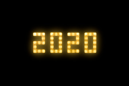 Close up yellow neon glowing bright led light 2020 year sign on black backgroundの写真素材