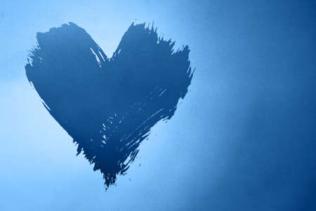 Abstract colorful background with brushstroke painted grunge blue heart over gradient noise grain texture with copy spaceの写真素材