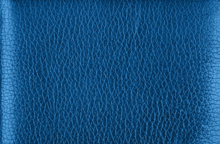 Close up background texture pattern of dark blue natural classic leather grain, directly above