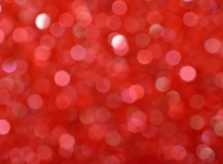 Abstract background of red bokeh defocused blurred lights and glitter sparkles