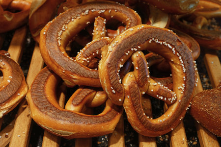 Close up several fresh traditional German pretzel bread knots on retail display, high angle side...
