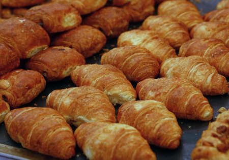 Close up several fresh baked artisanal French croissants on retail display, high angle viewの写真素材