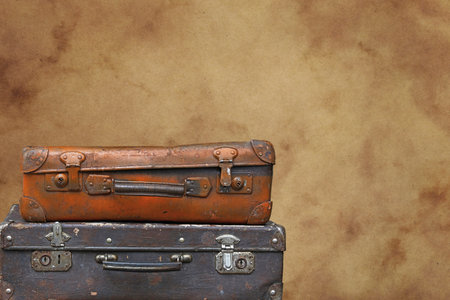 Close up stack of two old vintage antique grunge travel luggage brown leather suitcase trunks...